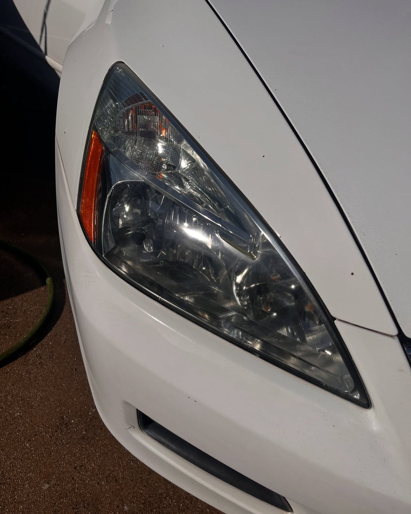 After headlight restoration — crystal-clear lens on the same white sedan, Adams Detailing Cumming GA