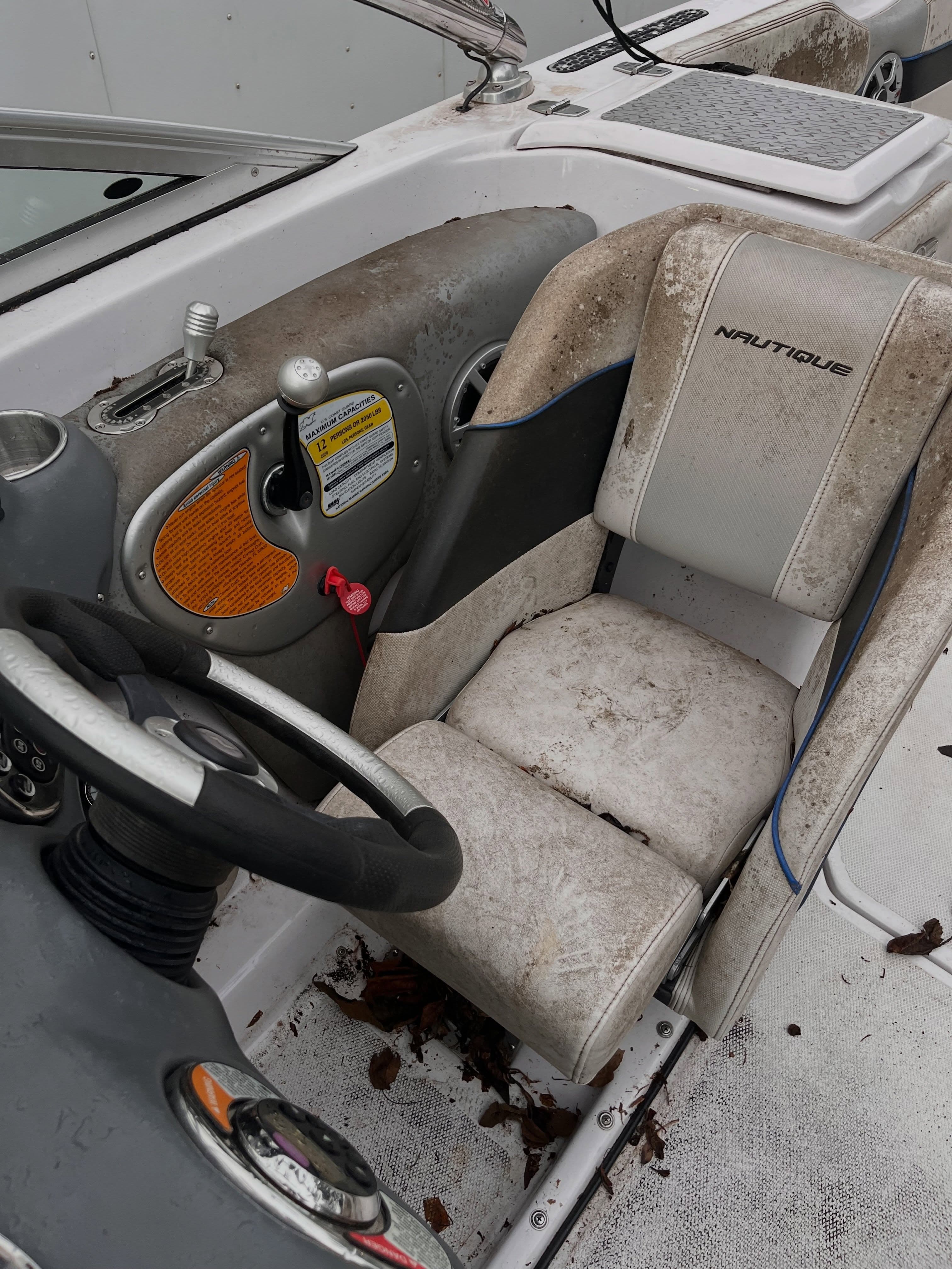 Dirt- and leaf-covered Nautique boat seat and helm before detailing, Lake Lanier GA