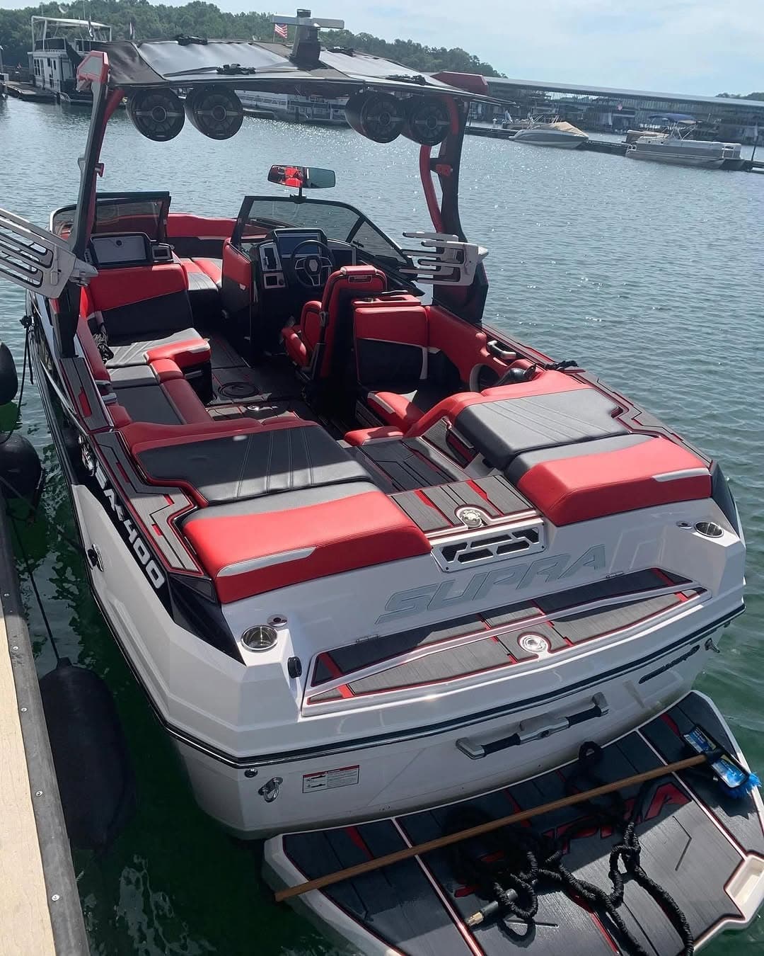 Stern view of a detailed red and black Supra wake boat with diamond-stitched seating, Lake Lanier