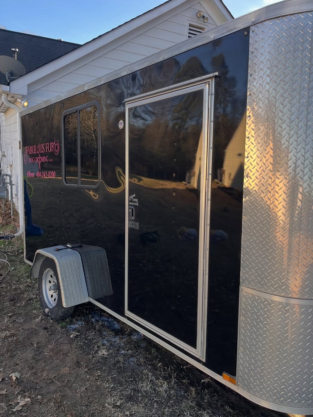 Mirror-gloss black panel on the same Fabulous Fur grooming trailer after 2-step paint correction, Forsyth County GA