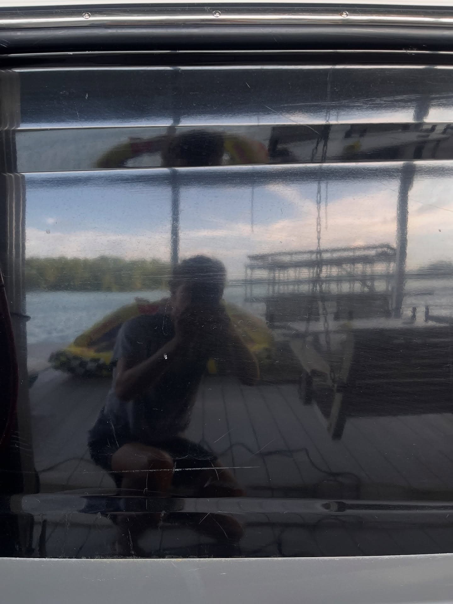 Hazy, scratched reflection on a boat's chrome/gelcoat trim before paint correction, Lake Lanier GA