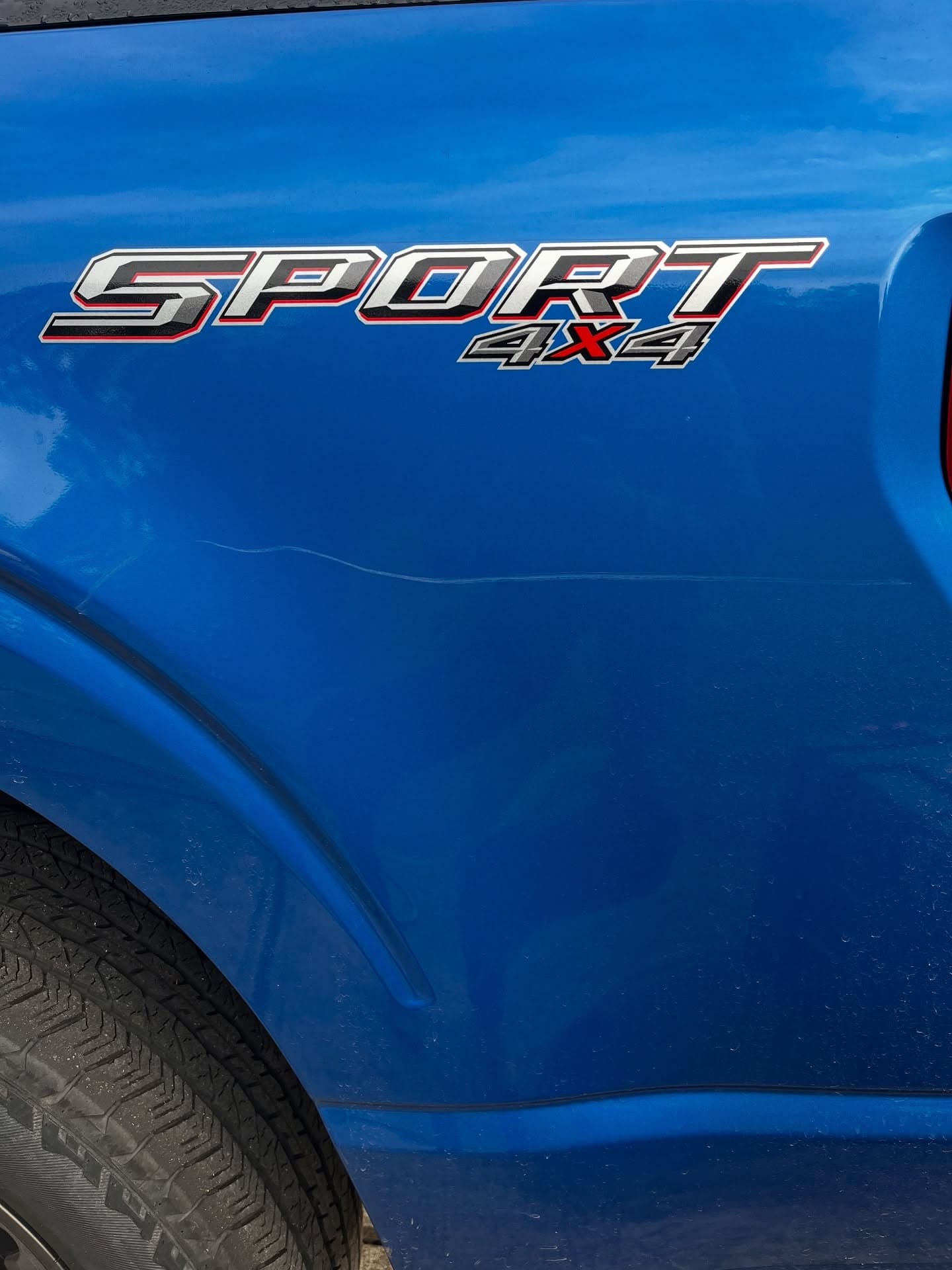 Before paint correction, deep scratch in blue truck fender clear coat, Cumming GA