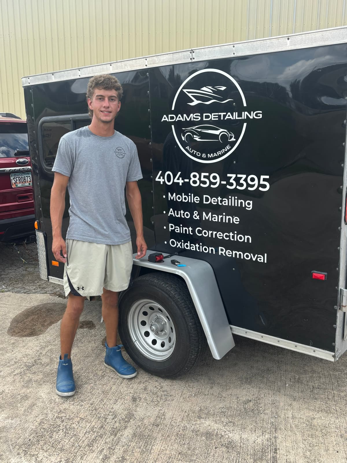 Peyton Adams, owner-operator of Adams Detailing, standing beside the Adams Detailing mobile trailer, Cumming GA